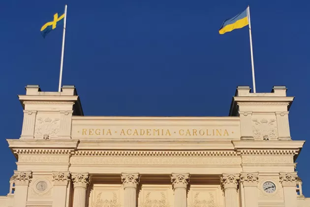 Foto på universitetshuset med en ukriansk och en svensk flagga.