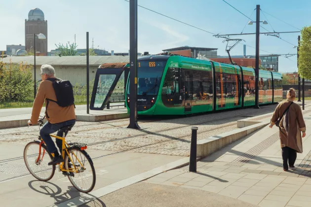 Bild på en cyklist och en spårvagn.