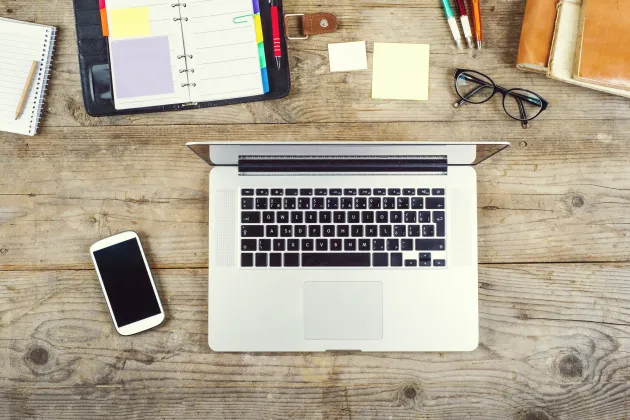 En laptop på ett skrivbord med en smartphone.