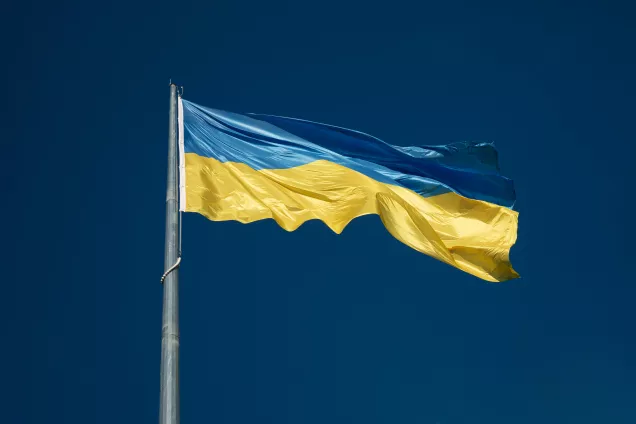 En ukrainskflagga mot en mörkblå bakgrund.