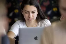 Ung kvinna framför en dator.