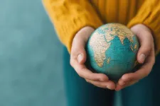 Två händer som håller en jordglob. Stockphotos.