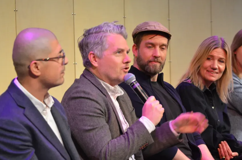Fyra personer på rad i ett panelsamtal.